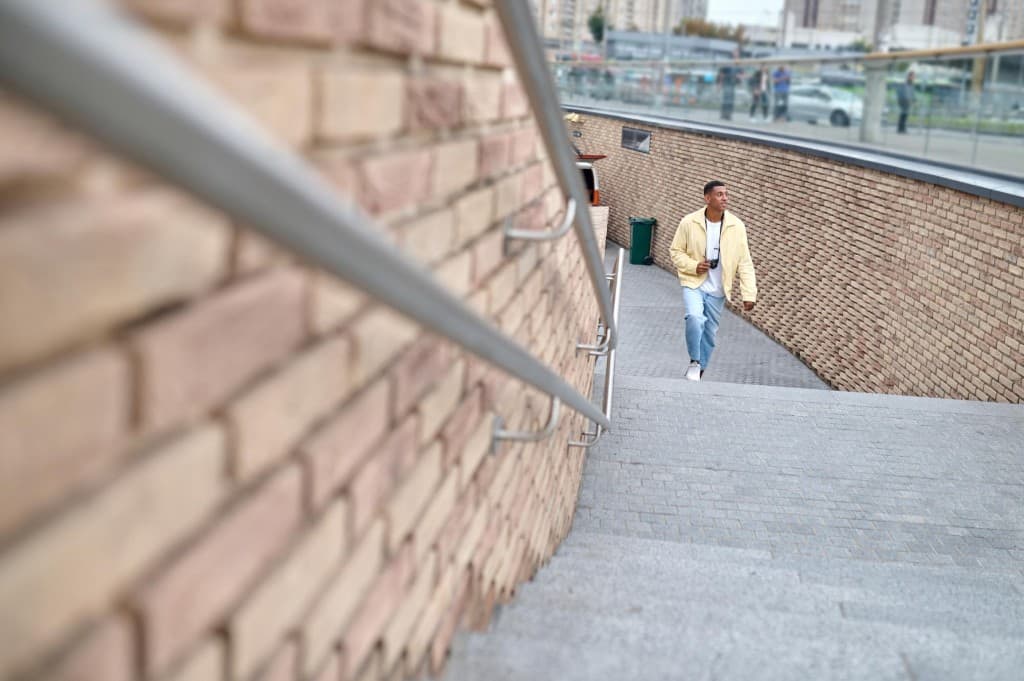 Student using campus stairs with handrails for accessible movement at BIHE
