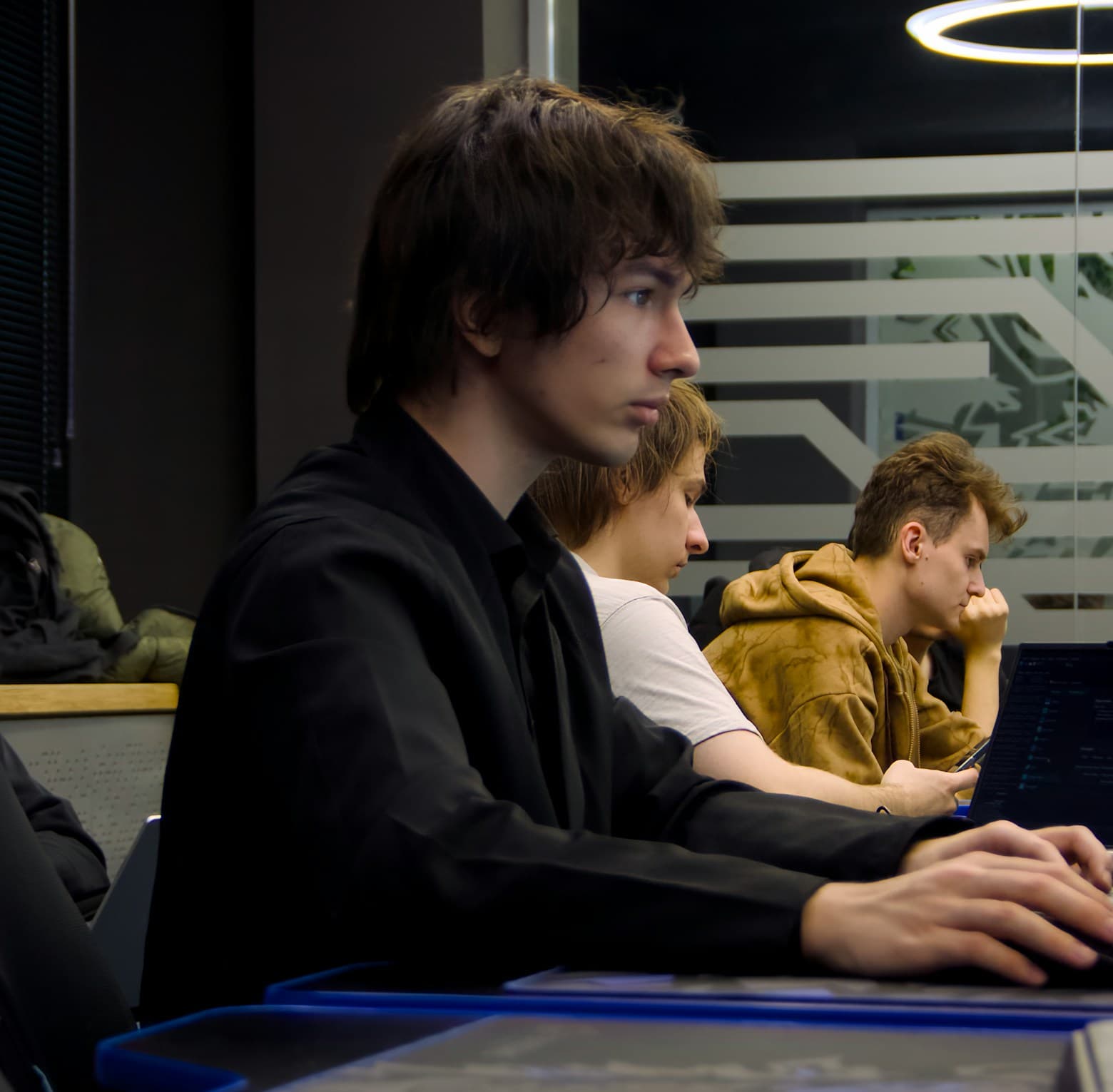 Male college student studying with a laptop in a classroom