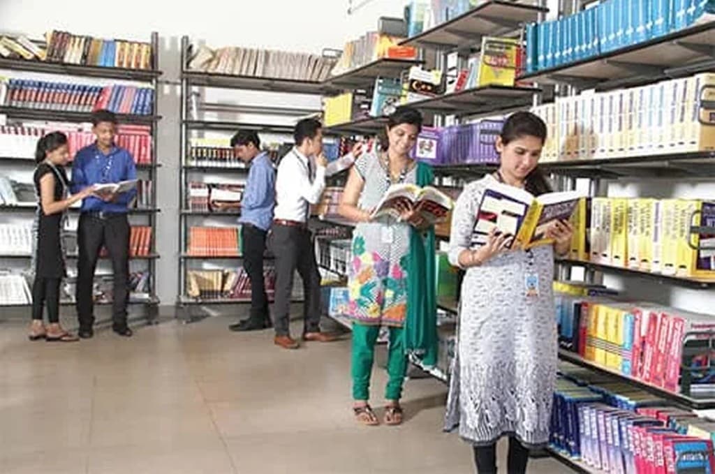 Students browsing books in the BIHE library reference section